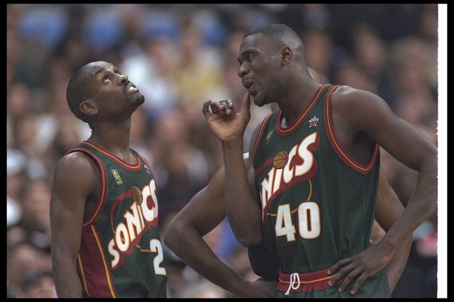 Gary Payton and Shawn Kemp talk to each other during a game.
