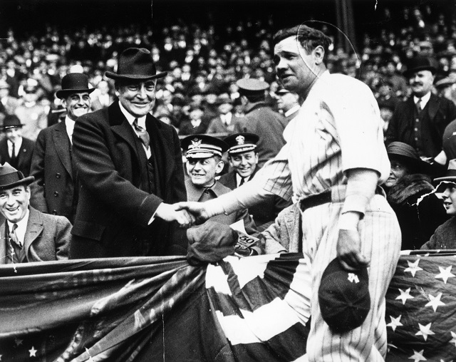 Babe Ruth shakes hands with a fan.