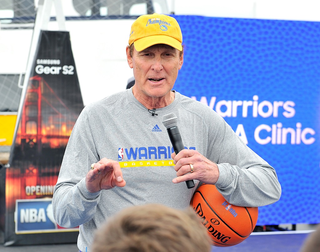 Rick Barry talks to fans at a basketball clinic.
