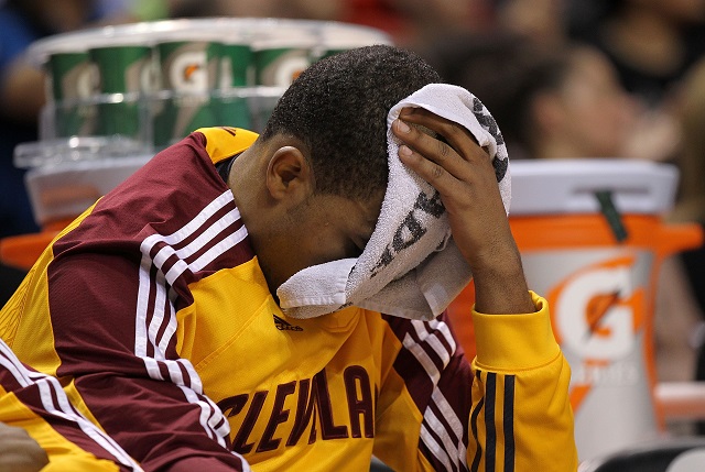 A Cleveland Cavaliers player puts a towel over his head while he sits on the bench.