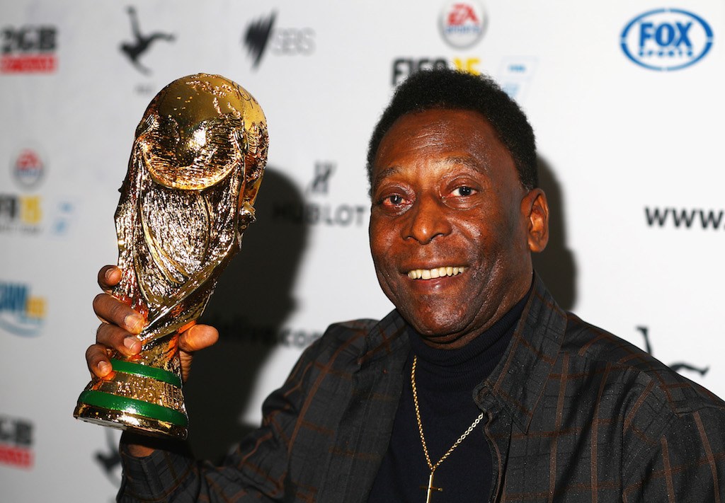 Pele holds a trophy.