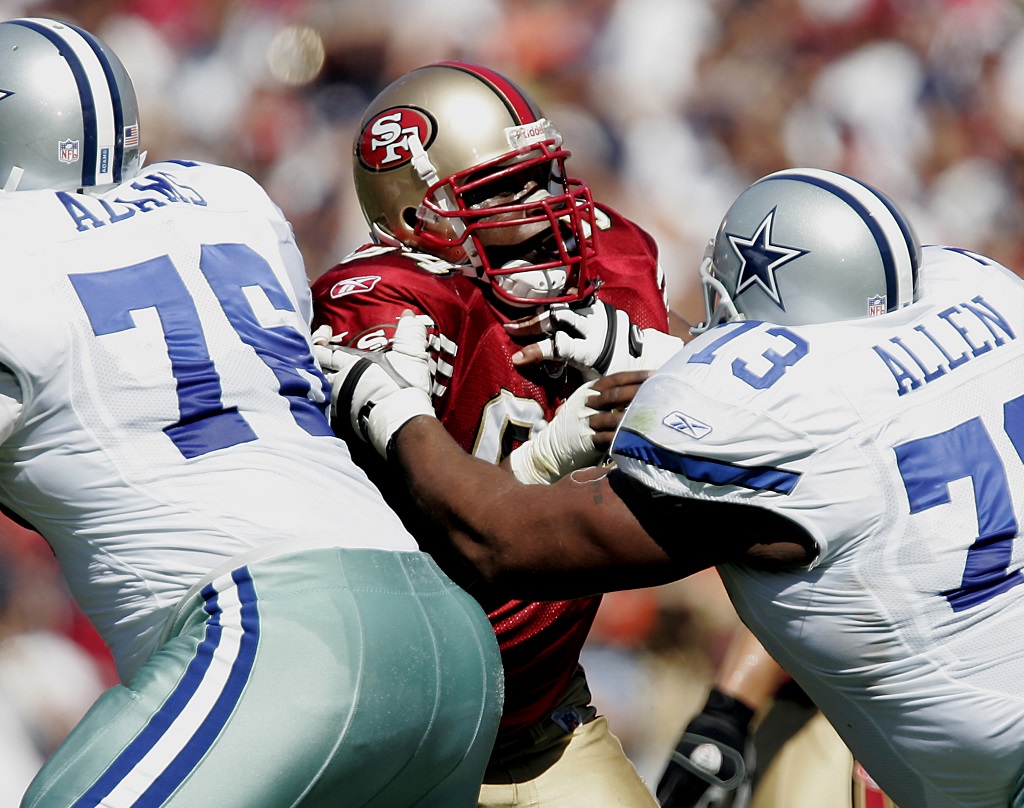 49ers defensive end Marques Douglas is stopped at the line by Dallas guard Larry Allen.