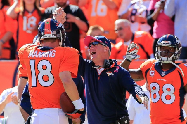 Peyton Manning celebrates with his coach as he walks off the field.