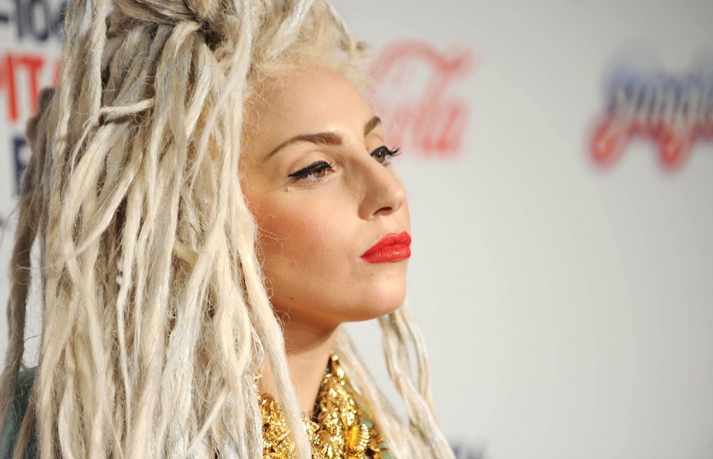 Lady Gaga smiles on the red carpet.