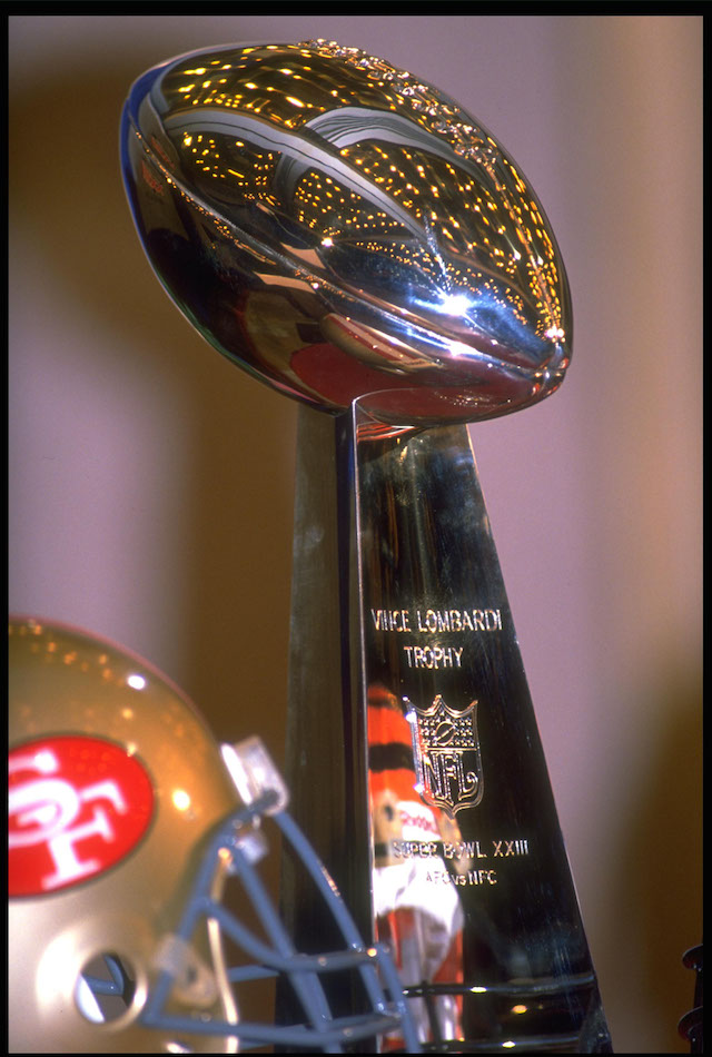 A San Francisco 49ers helmet rests next to the Lombardi Trophy.