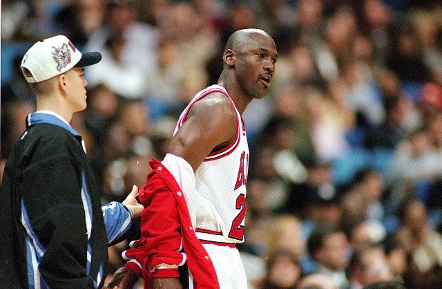Michael Jordan removing his jacket before a game.