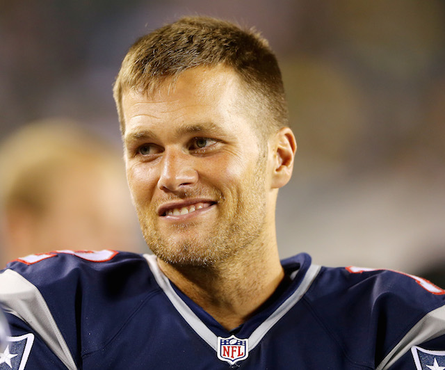 Tom Brady smiles with his helmet off.