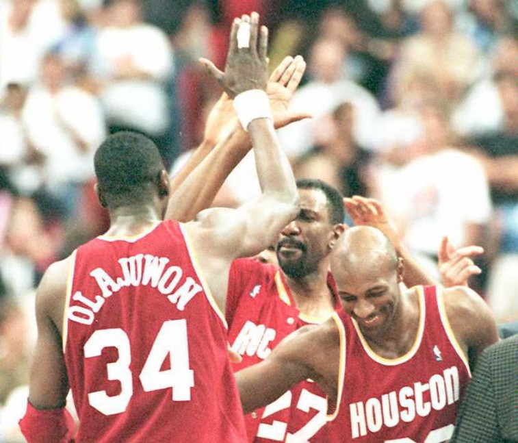 Members of the Houston Rockets high five each other and celebrate a victory.
