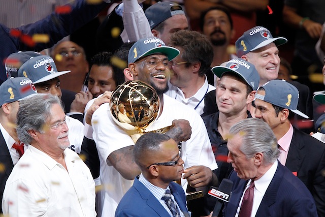 LeBron James hugs the Larry O'Brien Trophy after winning an NBA championship with the Miami Heat.