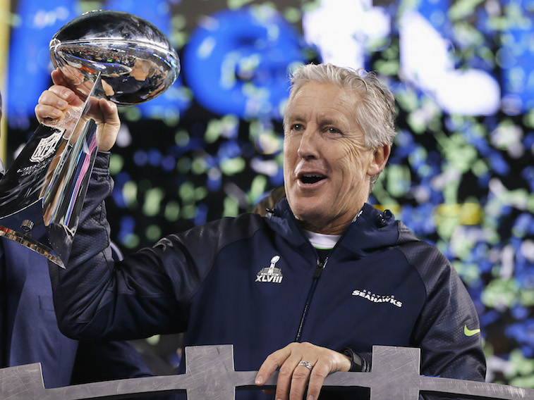 Pete Carroll celebrates winning the Super Bowl as he holds the Lombardi Trophy.