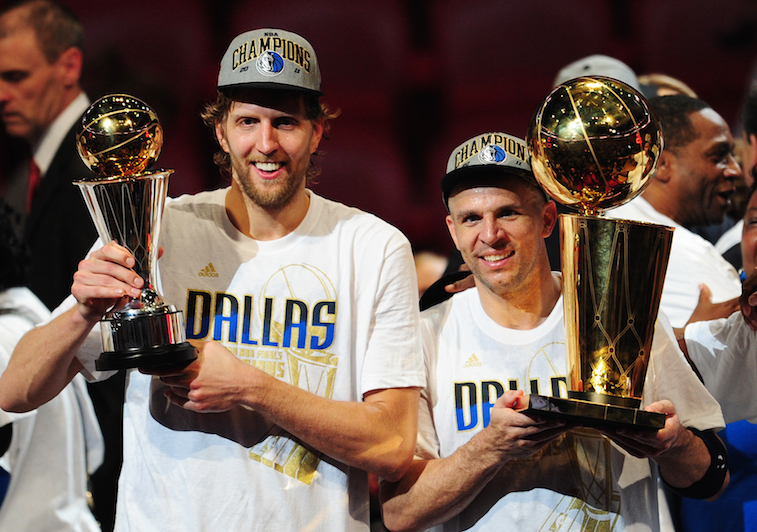 Members of the Dallas Mavericks hold up their championship trophies.
