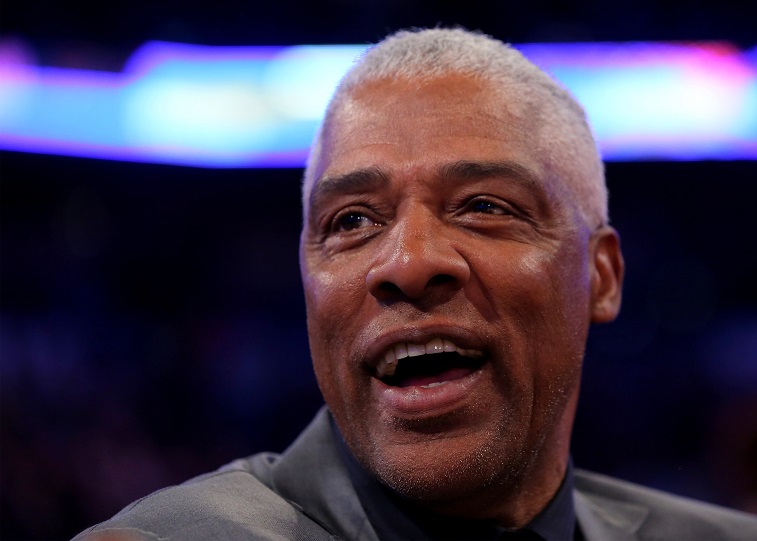 Julius Erving smiles on the sidelines.