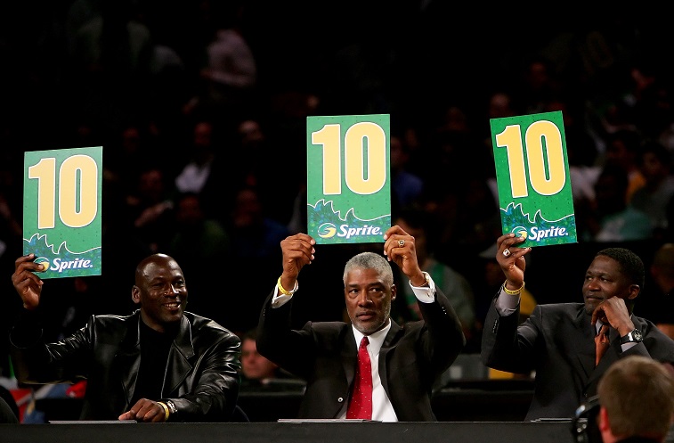 Michael Jordan (L) and Dominique Wilkins (C) hold up signs as they judge the Slam Dunk Contest.