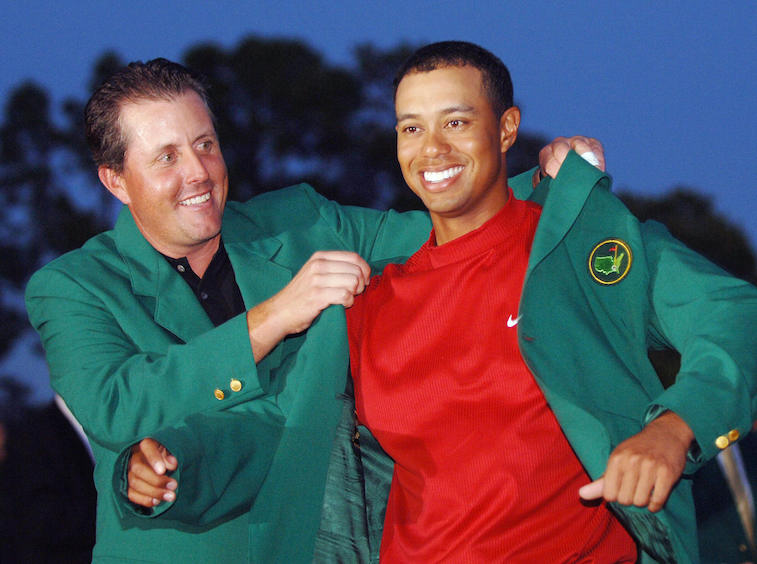 Phil Mickelson puts the Masters' green jacket on Tiger Woods.