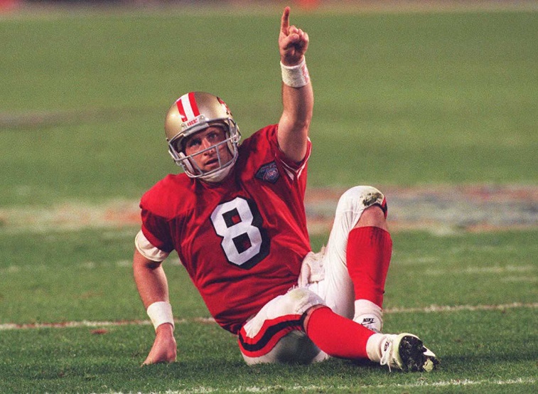MIAMI, :  San Francisco 49er quarterback Steve Young points towards the sky 29 January 1995 after throwing his third touchdown pass against the San Diego Chargers during Super Bowl XXIX in Miami. The 49ers lead the Chargers 28-10 at halftime.  (COLOR KEY:Red jersey)  AFP PHOTO (Photo credit should read TIMOTHY A. CLARY/AFP/Getty Images)