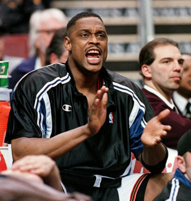 Rick Mahorn claps and shouts as he sits on the bench.