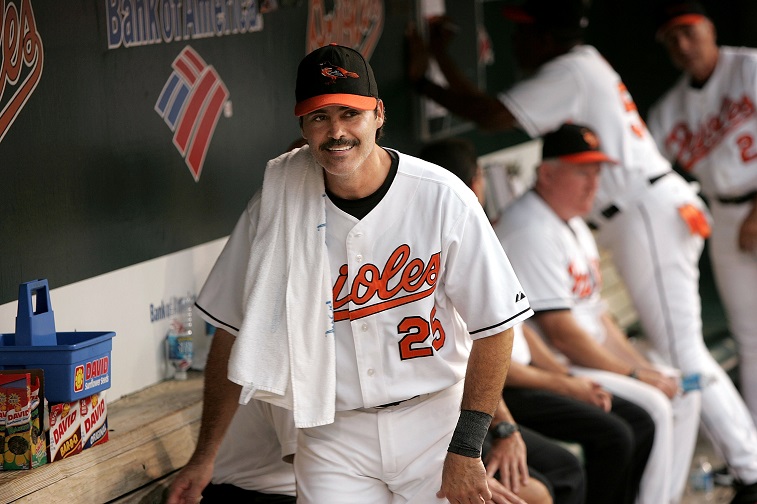 BALTIMORE - AUGUST 11: Rafael Palmeiro #25 of the Baltimore Orioles jokes with teammates in the dugout between innings against the Tampa Bay Devil Rays on August 11, 2005 at Oriole Park at Camden Yards in Baltimore, Maryland. Palmeiro returns from his 10-day suspension by Major League Baseball for violating the league's steroids policy after failing a drug test.