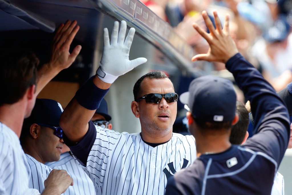 Alex Rodriguez high fives his teammates after hitting a home run.