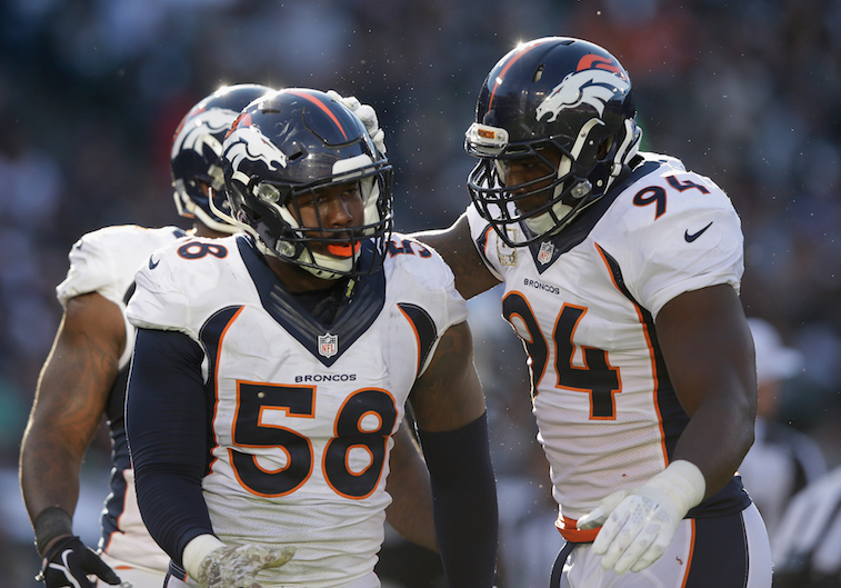 Von Miller #58 and DeMarcus Ware react to a play