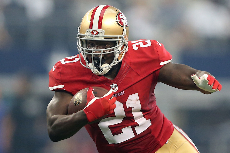 Frank Gore grabs the ball and runs downfield.