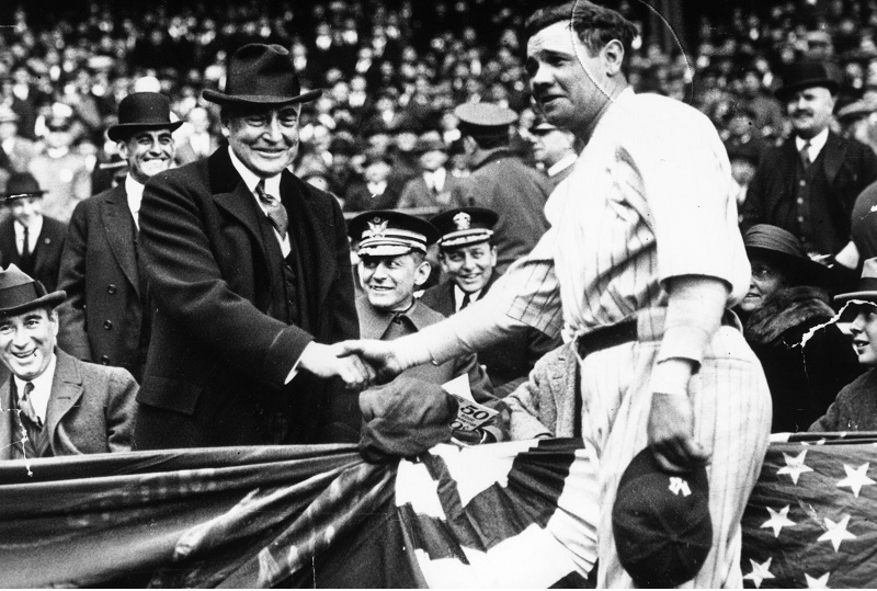 Babe Ruth shakes hands with a spectator.