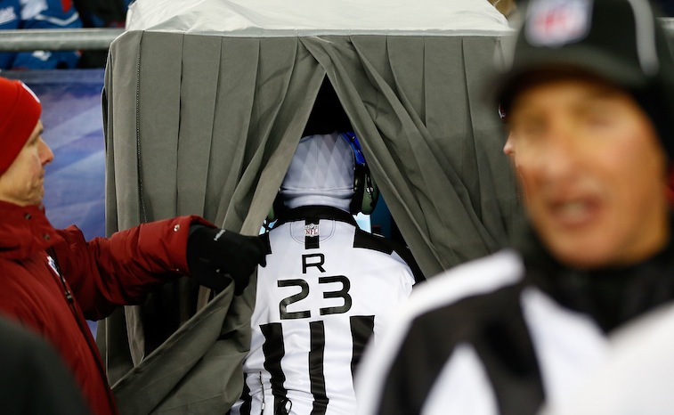 Referee Jerome Boger looks at the screen in the instant replay booth during the game
