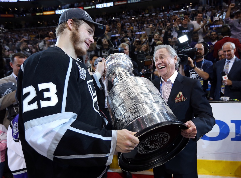 Dustin Brown hands over the Stanley Cup to Kings team owner Philip Anschutz