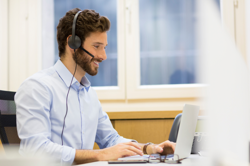 Happy Businessman in the office on the phone, headset, Skype Happy Businessman in the office on the phone, headset, Skype