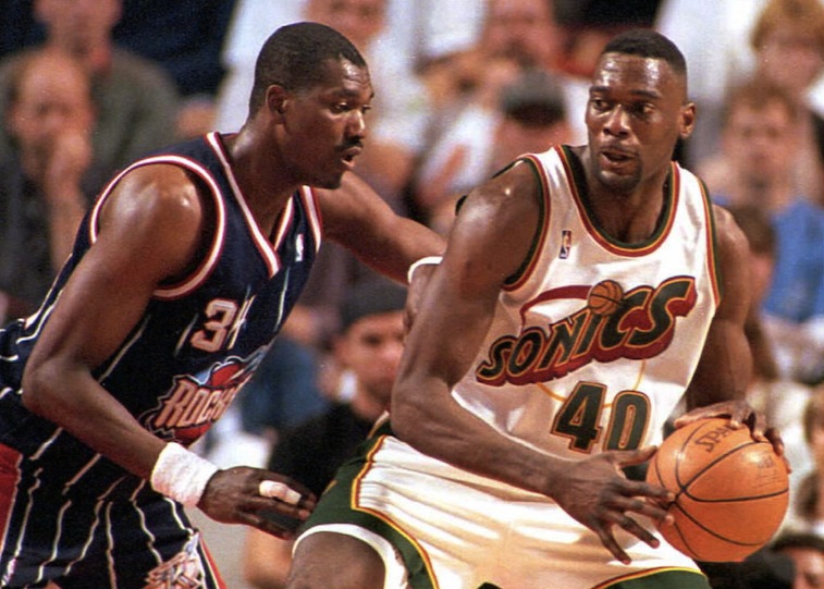  Le centre des Rockets Hakeem Olajuwon (L) défend Shawn Kemp au poste 