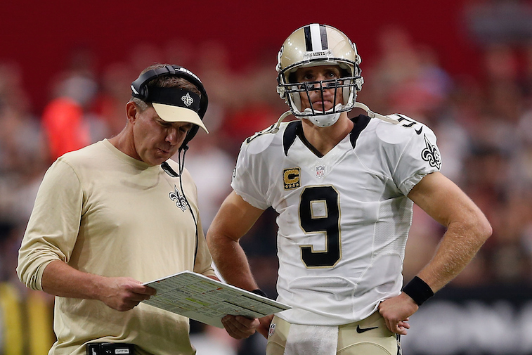 Sean Payton and Drew Brees talk on the sidelines during a game.
