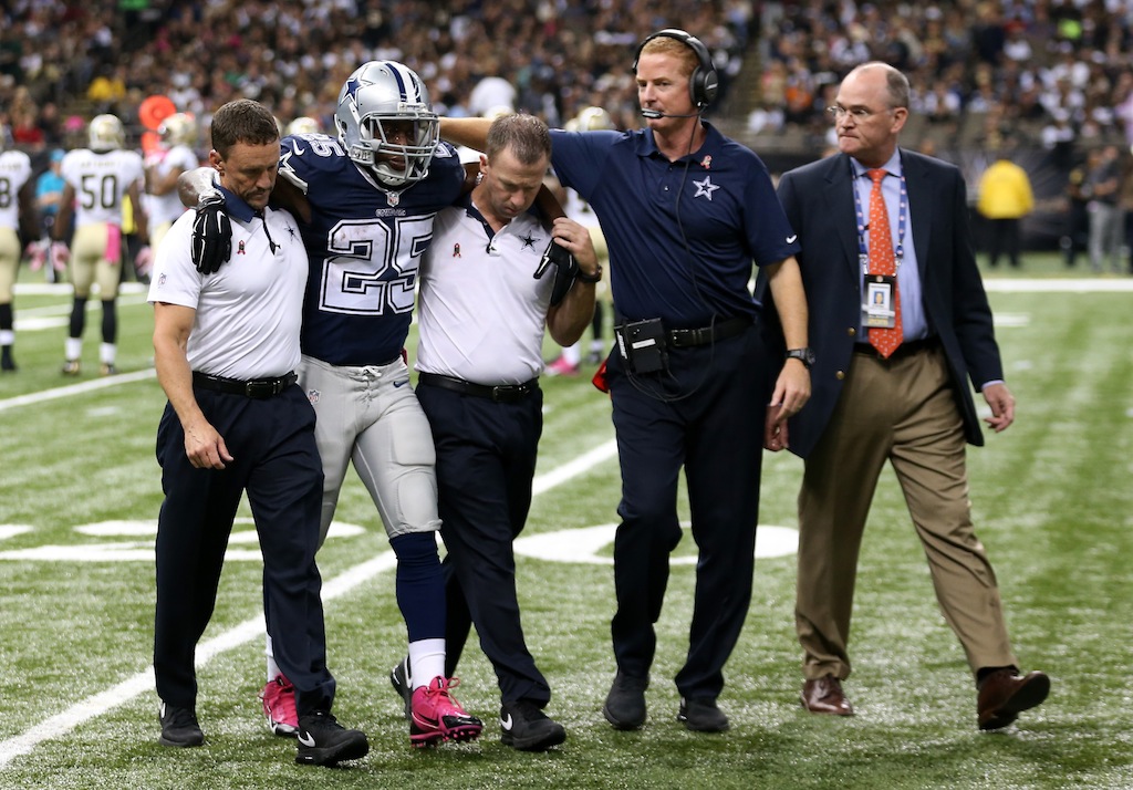 Lance Dunbar of the Dallas Cowboys is helped off the field