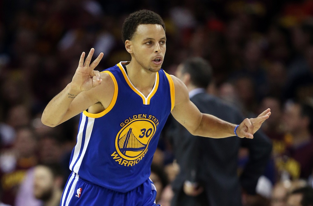 Stephen Curry holds up three fingers after draining a three.