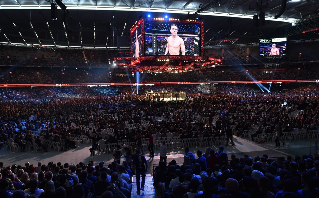 PAUL CROCK/AFP/Getty ImagesA large crowd watches a preliminary bout ahead of the UFC title fight between Ronda Rousey of the US and compatriot Holly Holm in Melbourne on November 15, 2015. RESTRICTED TO EDITORIAL USE NO ADVERTISING USE NO PROMOTIONAL USE NO MERCHANDISING USE. AFP PHOTO/Paul CROCK (Photo credit should read PAUL CROCK/AFP/Getty Images)