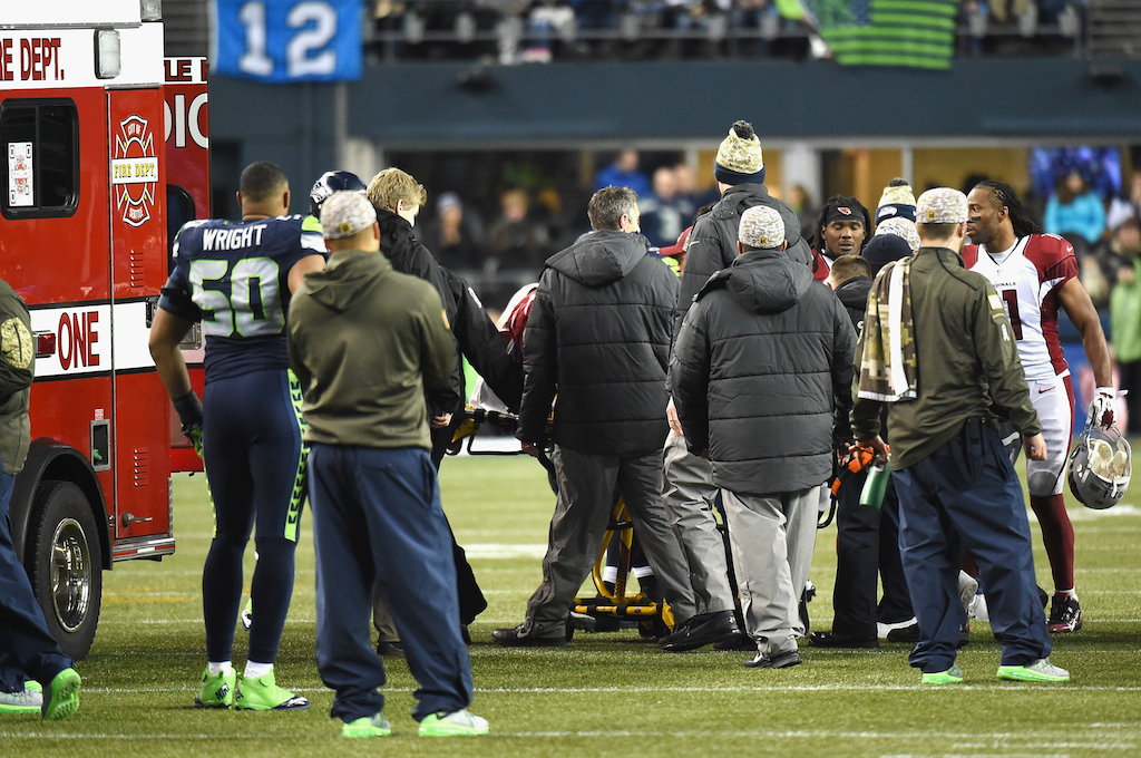 Mike Iupati (obscured) is taken off the field on a stretcher