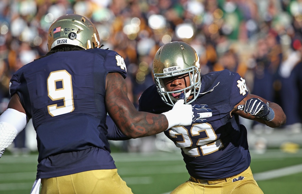 Elijah Shumate #22 of the Notre Dame Fighting Irish celebrates his first interception of the game with teammate Jaylon Smith #9