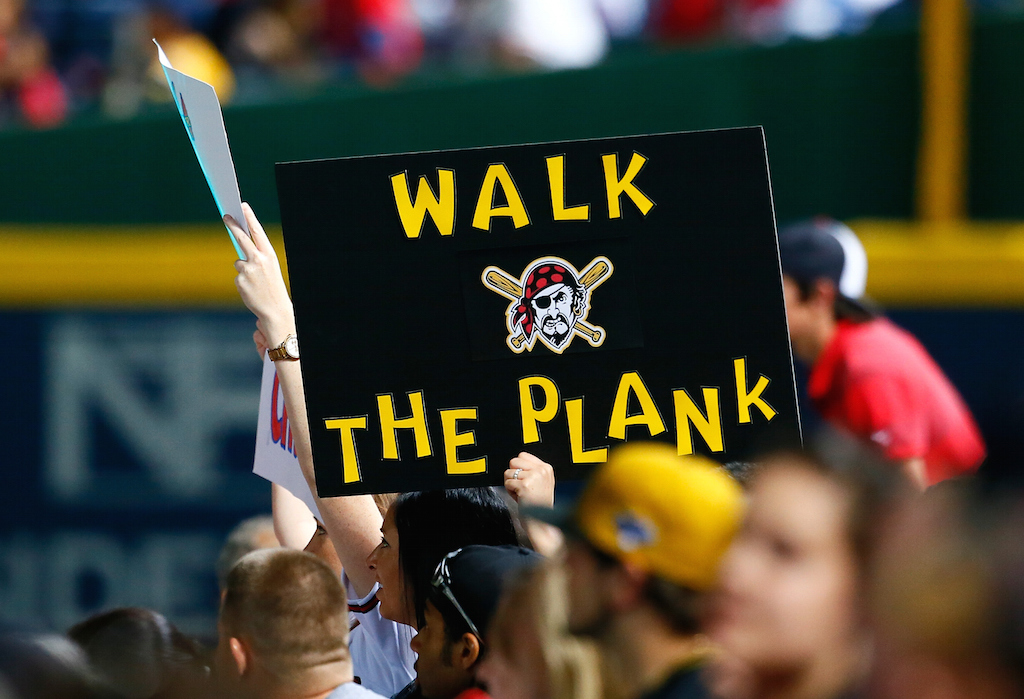 Pirates fans hold a sign that says, "Walk the Plank."