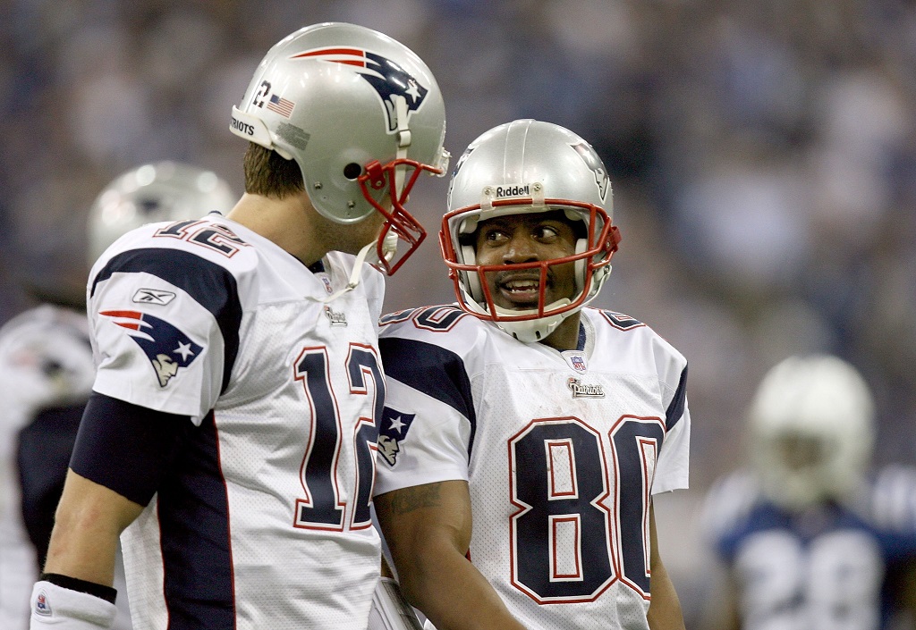 Tom Brady and Troy Brown talk as they walk off the field.