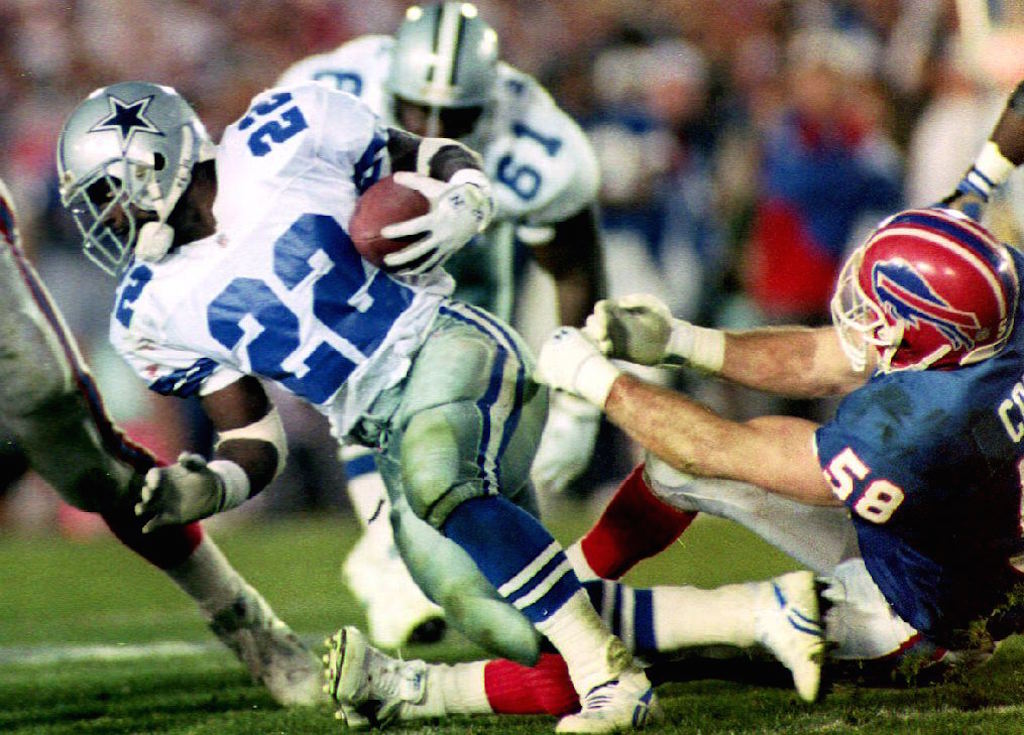 Emmitt Smith (L) breaks a tackle by Buffalo Bills linebacker Shane Conlan (R) 31 January, 1993 during fourth quarter action in Super Bowl XXVII