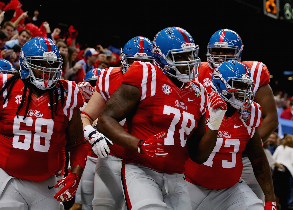 Laremy Tunsil #78 of the Mississippi Rebels celebrate his touchdown with teammates