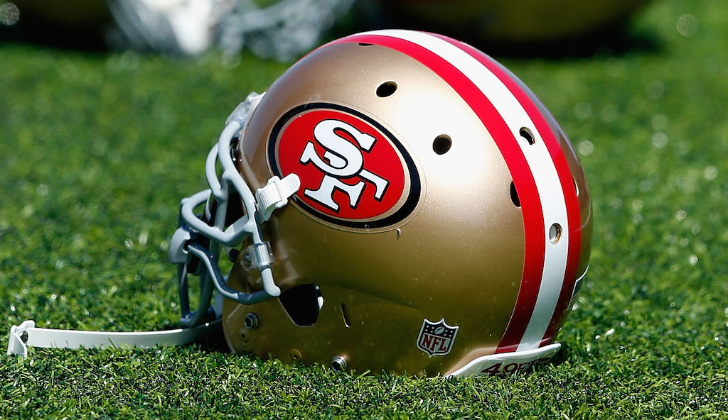 A 49ers helmet rests on the grass.