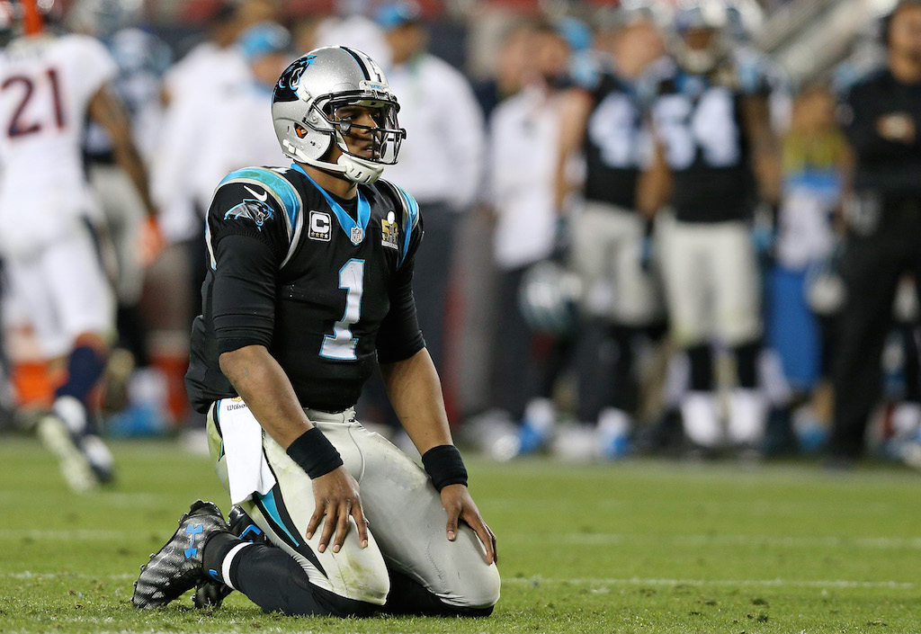 Cam Newton sinks to the ground after throwing an interception.