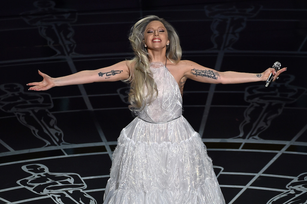 Lady Gaga smiles onstage at 87th Annual Academy Awards.