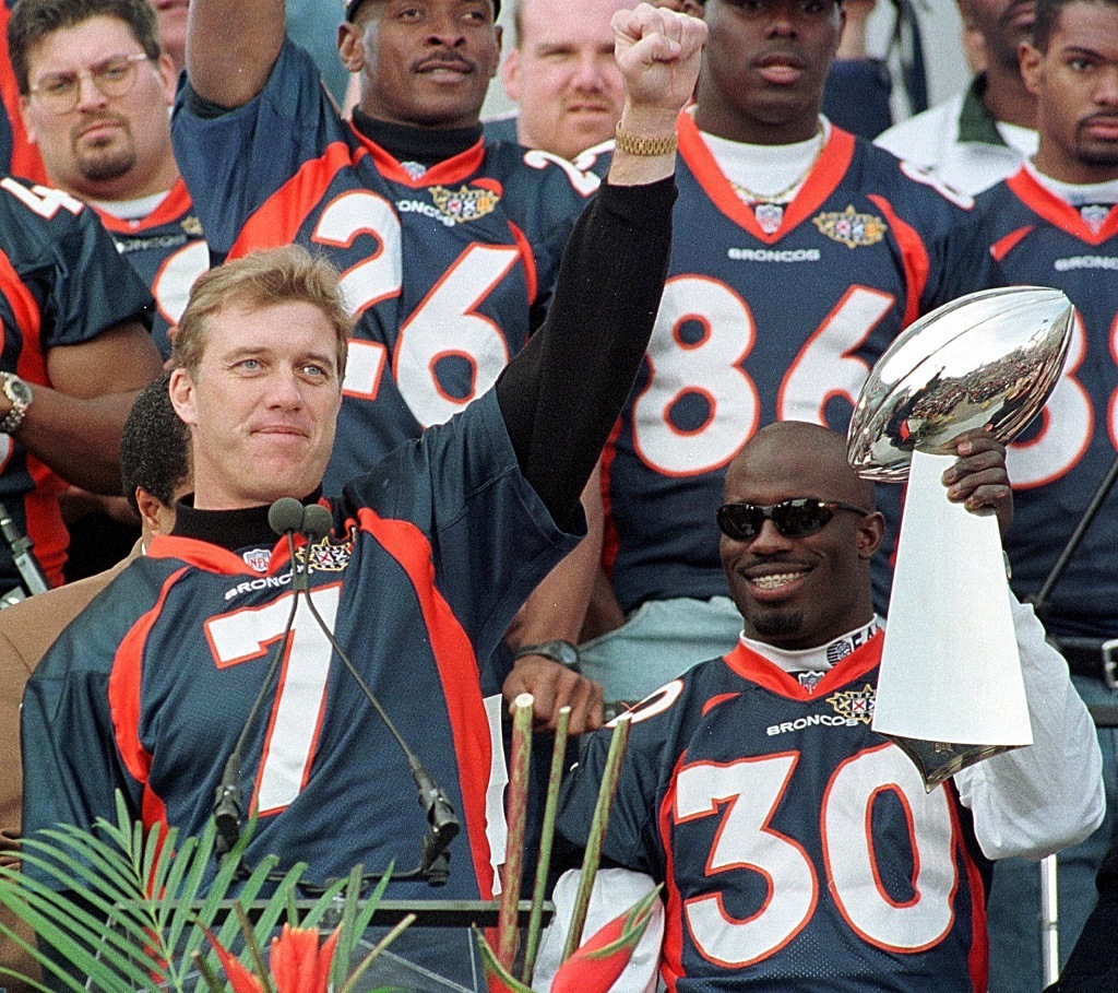 DENVER, CO - 27 Jan 1998: Denver Broncos quarterback John Elway (L) salutes the crowd while Super Bowl MVP Terrell Davis holds the Vince Lombardi Trophy during a rally and victory parade 27 January at the City and County Building in Denver Colorado. Thousands attended the celebrations for the Broncos' victory over the Green Bay Packers in Super Bowl XXXII. (Photo credit should read DOUG COLLIER/AFP/Getty Images)