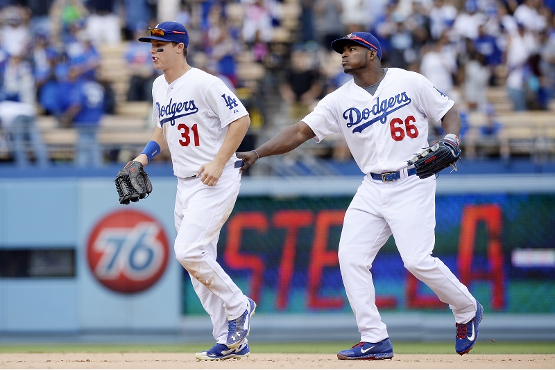 LOS ANGELES, CA - OCTOBER 4: Yasiel Puig #66 of the Los Angeles Dodgers jokingly pulls back Joc Pederson #31 as they run in from the outfield after defeating the San Diego Padres 6-3 at Dodger Stadium October 4, 2015, in Los Angeles, California. (Photo by Kevork Djansezian/Getty Images