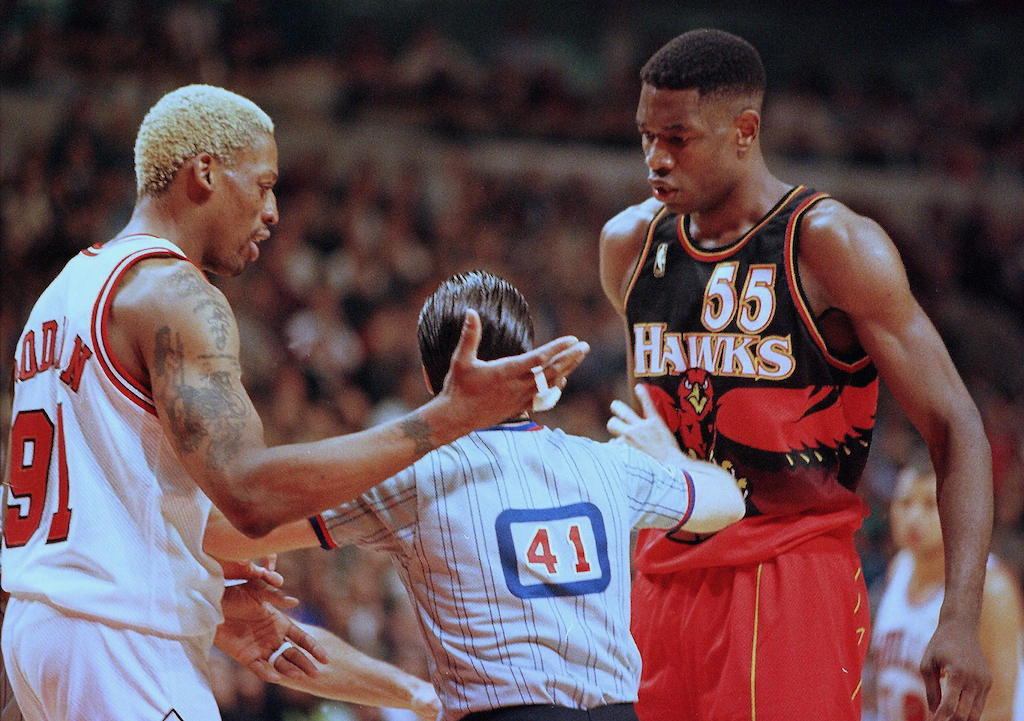 Dennis Rodman (L) en Dikembe Mutombo worden gescheiden op het Hof door een ref