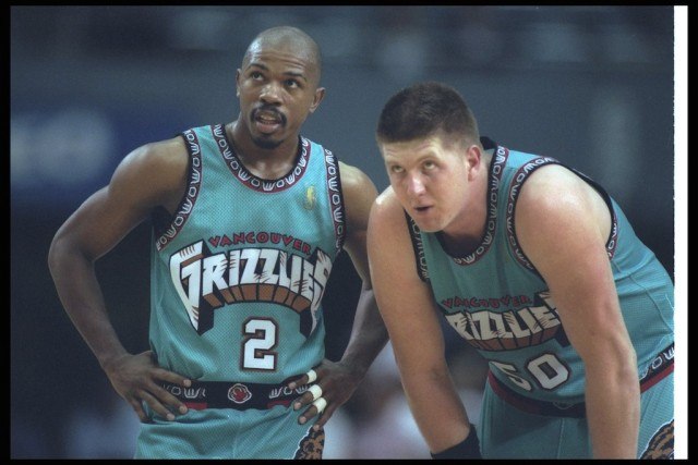 Vancouver's Greg Anthony (L) and Bryant Reeves look on during a game against the Clippers.