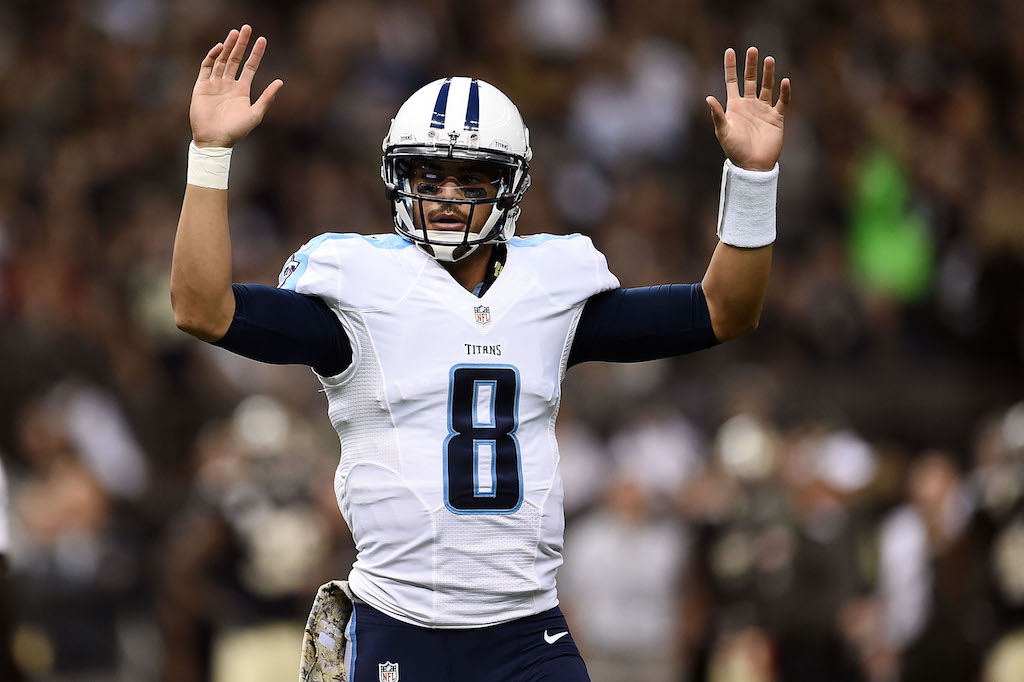 Marcus Mariota throws his arms in the air.