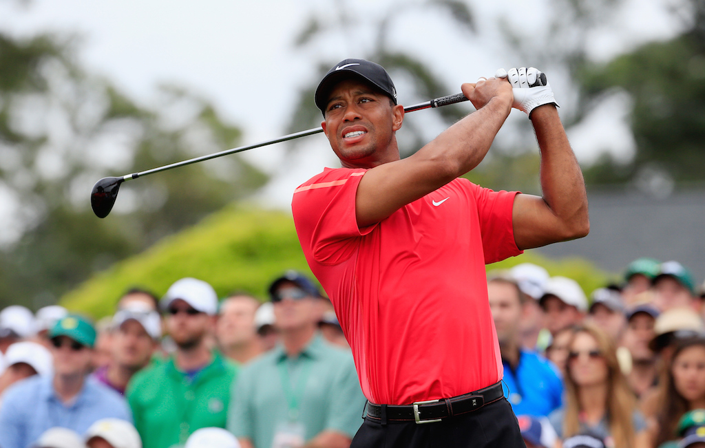 Tiger Woods is swinging as he plays golf.