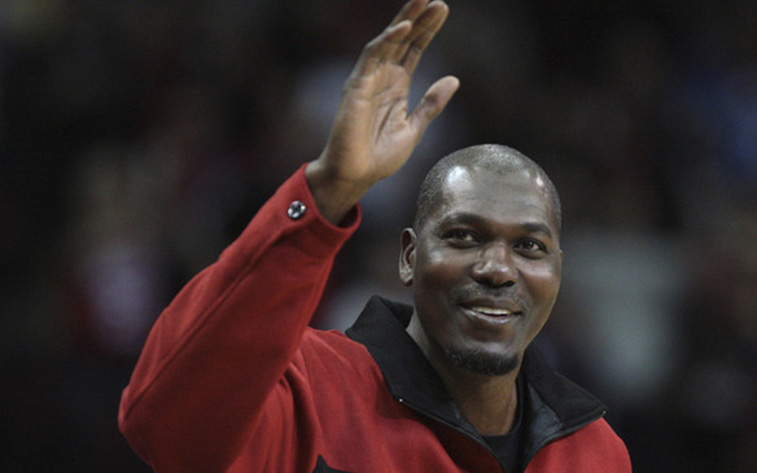 Hakeem Olajuwon of the Houston Rockets waves at fans.