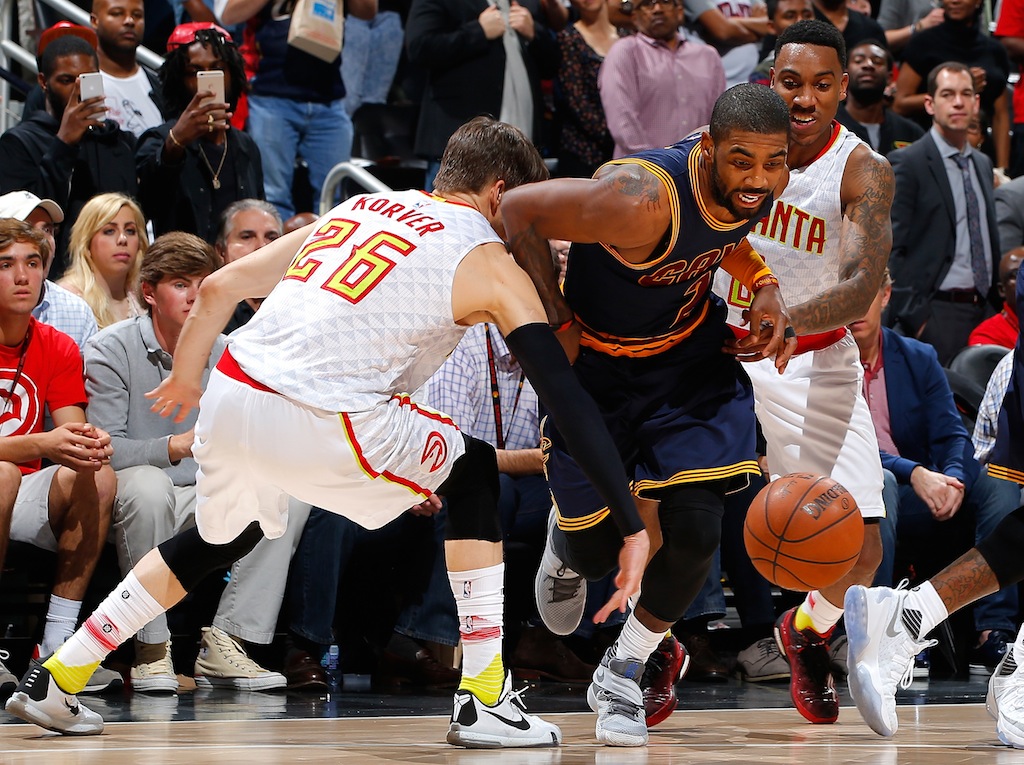 Kyrie Irving dribbles the ball through the Hawks. Kyrie Irving splits the Atlanta defense.